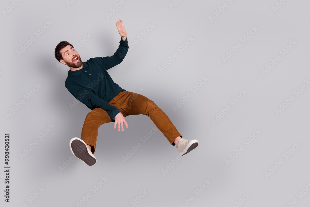 Photo of stressed frightened man wear stylish green clothes look empty space isolated on gray color background
