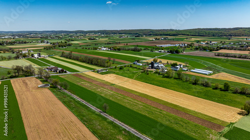 This captivating landscape showcases expansive farmland with a patchwork of green and brown fields