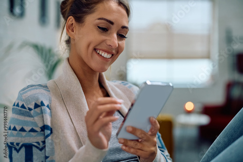 Happy woman reading text message on mobile phone at home. Free Download Happy woman reading text message on mobile phone at home. - GFXLoad