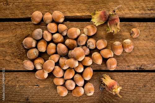 Freshly harvested hazelnuts on rustic wooden surface, high angle view