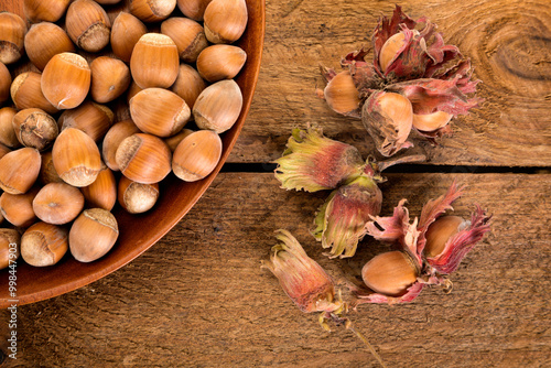 Freshly harvested hazelnuts on rustic wooden surface, high angle view