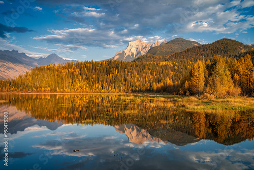 Calm lake reflecting mountain peak and autumn foliage