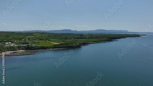 Rossnowlagh Beach, County Donegal, Ireland, June 2023. Drone tracks along the coast above the cystal clear water revealing the sandy beach as tourists and families enjoy the spectacular sunshine. photo