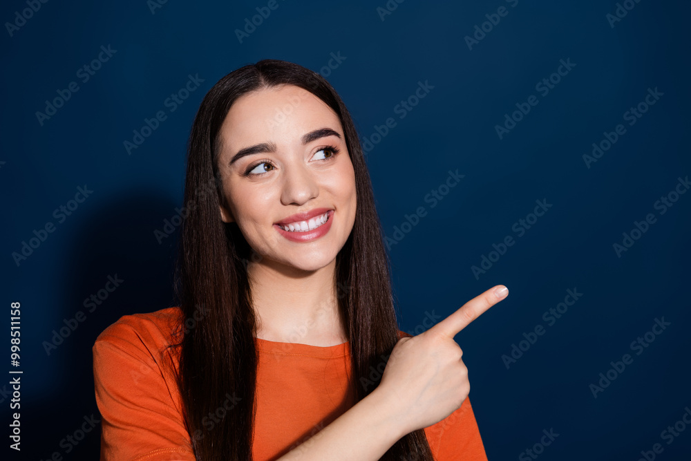 Photo of adorable cute gorgeous woman wear orange clothes presents empty space isolated on dark blue color background Photo of adorable cute gorgeous woman wear orange clothes presents empty space isolated on dark blue color background