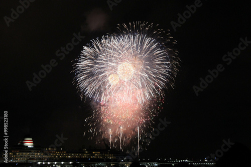 Fireworks exploding over cruise ship at night port with dramatic travel vibe