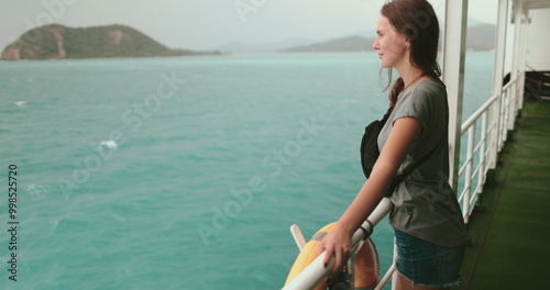 Obraz na plátne A woman stands on a boat, gazing out at the vast ocean during a ferry journey from Surat Thani to Koh Phangan Island in Thailand