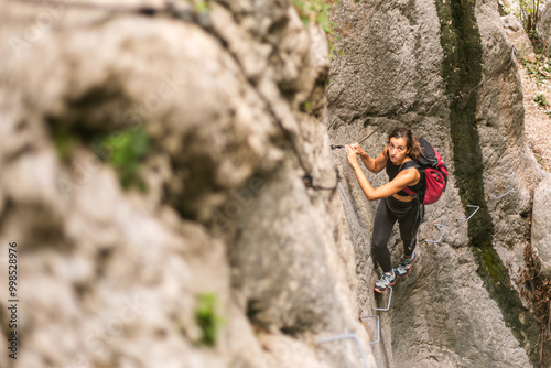 A strong woman going for a hike on a via ferrata in the nature