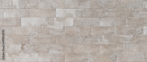 Panoramic texture background of a wall with smooth stone tiles in neutral tones and straight lines