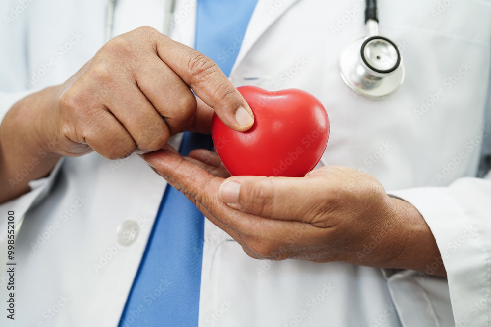 Asian doctor holding red heart in hospital, cardiovascular disease, CVD. Asian doctor holding red heart in hospital, cardiovascular disease, CVD.