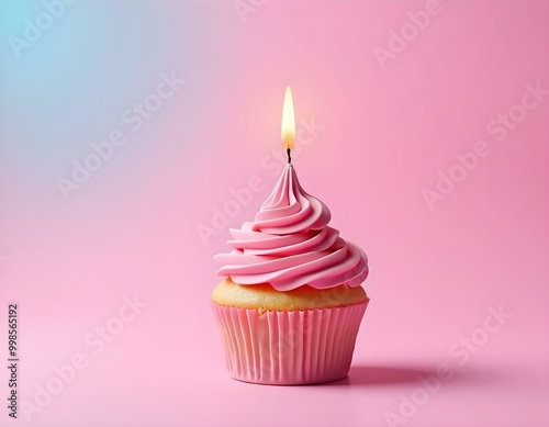 A pink cupcake with a single lit candle on a pink background with a blue sky gradient.