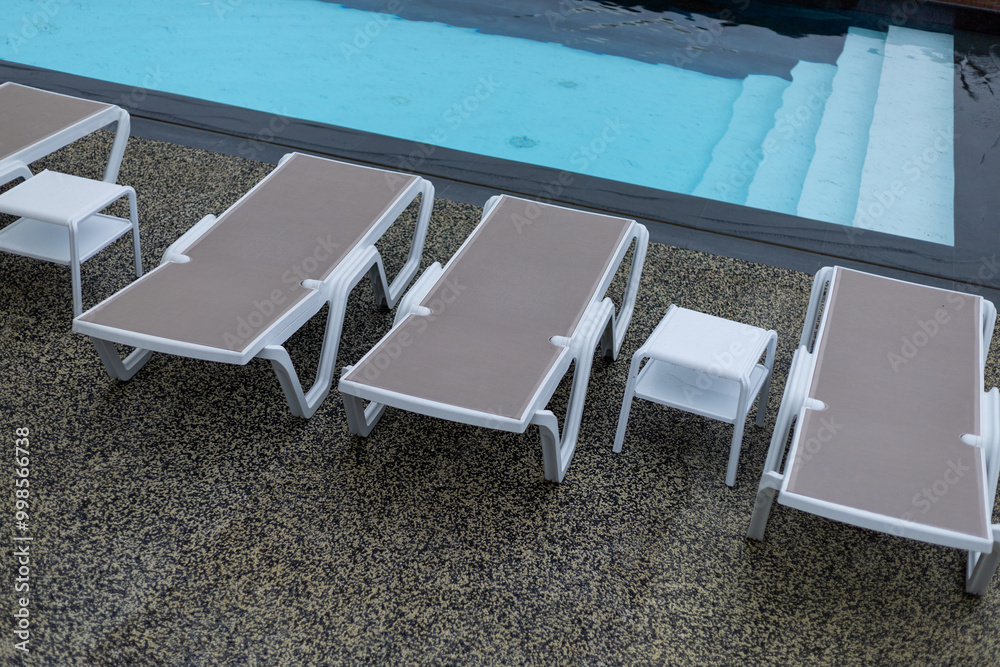 white plastic sunbeds by the pool white plastic sunbeds by the pool