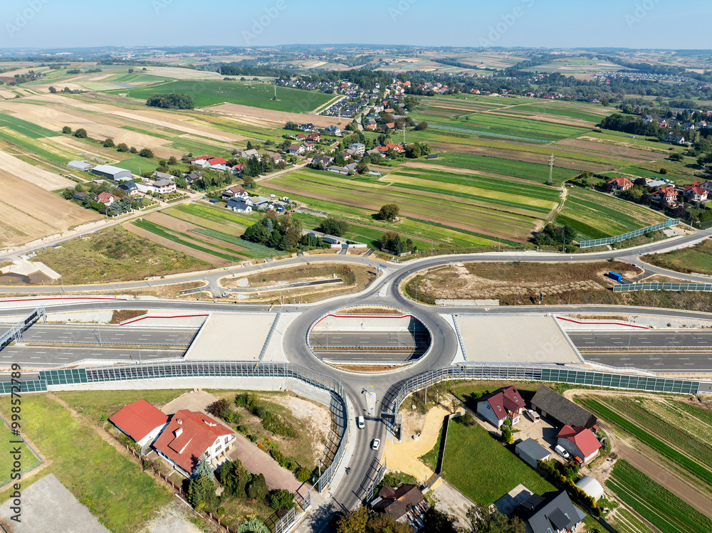 Krakow, Poland. Batowice highway interchange in construction on S53. part of motorway ring road around Cracow. Traffic circle with a hole inside, viaducts, tunnels, ramps. September 2024. Aerial view