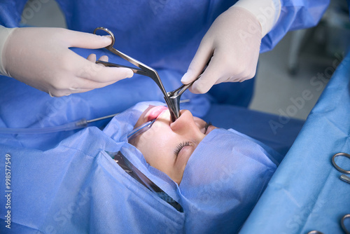 Otolaryngologist surgeon performs a maxillary antrotomy on a patient under general anesthesia