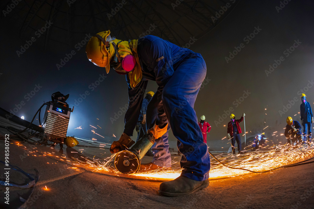 Male worker grinding on steel plate with flash of sparks close up wear protective gloves oil inside Male worker grinding on steel plate with flash of sparks close up wear protective gloves oil inside