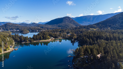 Looking straight onto a mountain and valley sitting behind Gerrans Bay, Sunshine Coast, British Columbia. Calm water and clear skies on a sunny morning