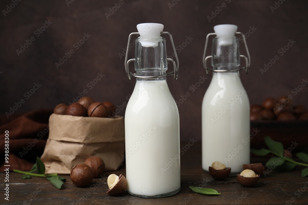 Bottles of macadamia milk and nuts on wooden table Bottles of macadamia milk and nuts on wooden table