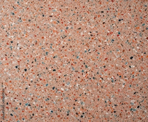 a close-up view textured surface composed of small, irregularly shaped stones in various shades of orange, pink, and white, arranged in a random pattern