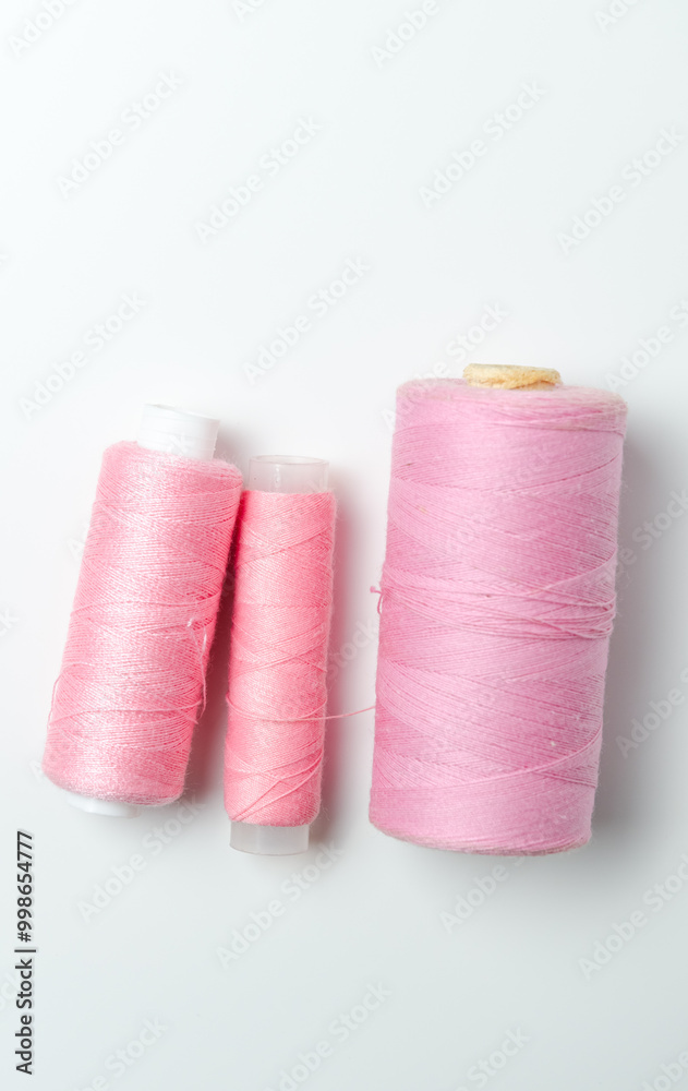 Pink thread spools on white background. Pink thread spools on white background.