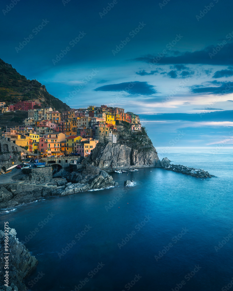Fototapeta premium Manarola village, rocks and sea in blue hour. Cinque Terre, Italy.