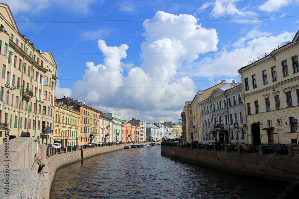 Fototapeta premium A picturesque street view along an embankment with historic buildings in a European city. The calm atmosphere and traditional architecture create a serene urban landscape.