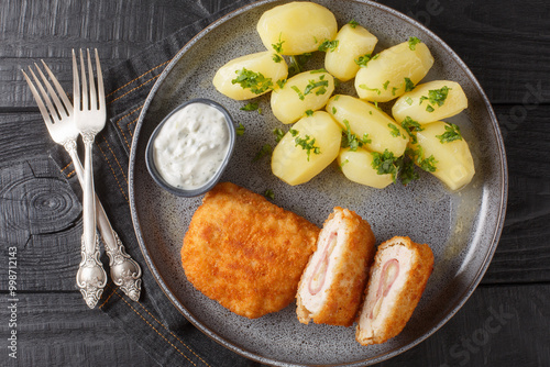 Canvastavla Tasty Chicken Cordon Bleu served with new potatoes and cream sauce closeup on the plate on the table