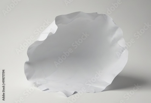 A white paper sheet is crumpled and tilted to the right, creating a dynamic and abstract composition against a plain white background