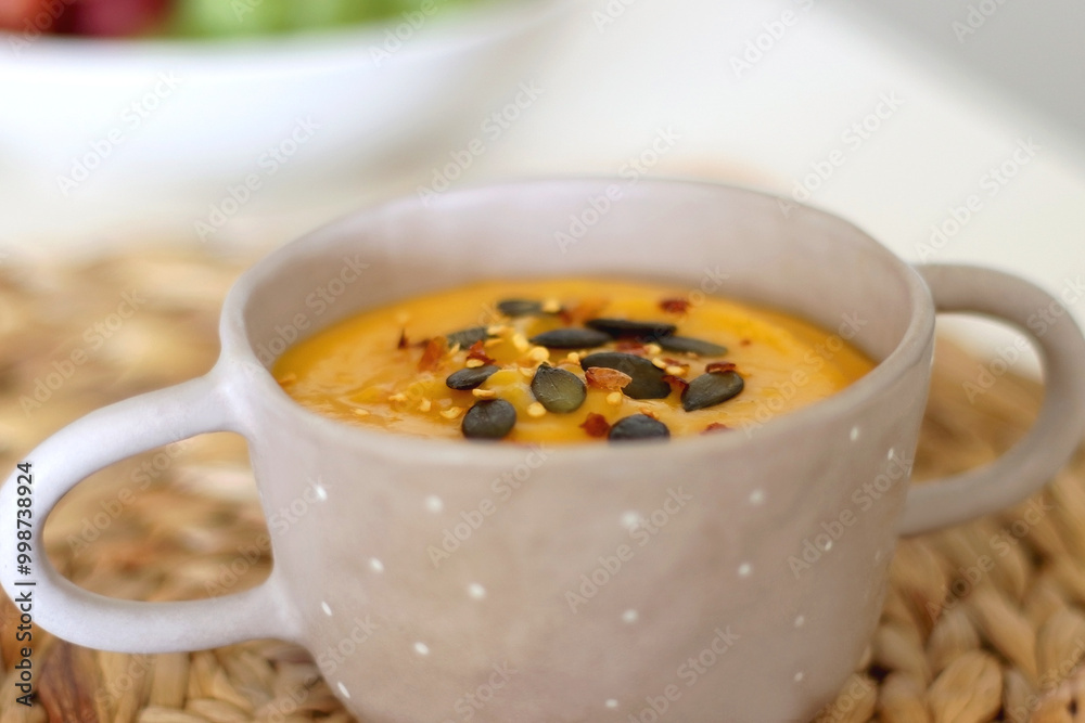 Pumpkin and potato creamy soup, bowl of grapes, jars of nuts and autumn leaves on the table. Selective focus. Pumpkin and potato creamy soup, bowl of grapes, jars of nuts and autumn leaves on the table. Selective focus.