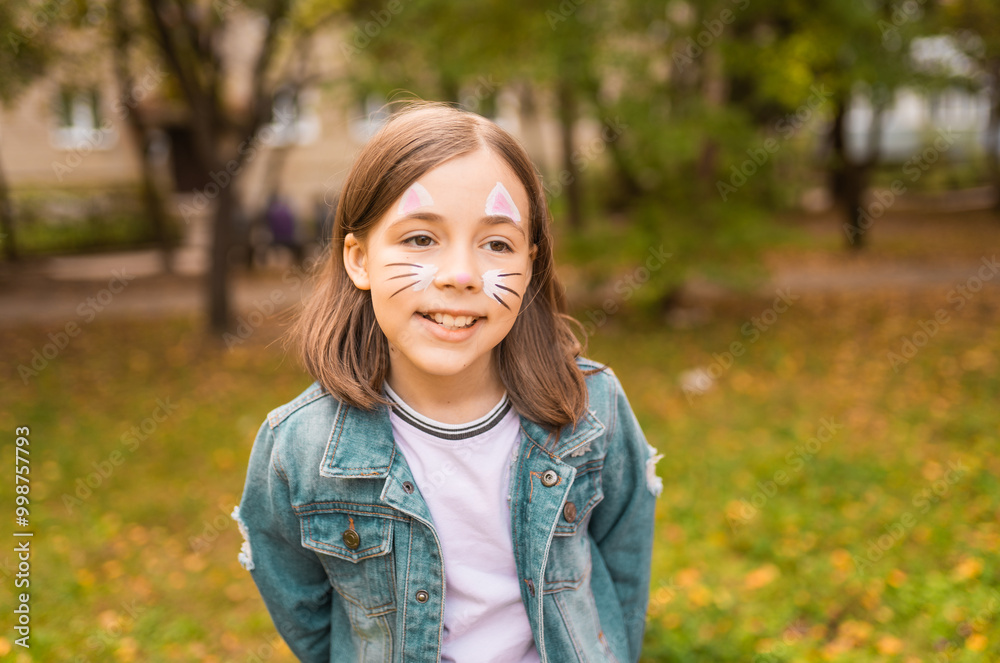 Portrait of a cute little girl with face painting of a cat outdoors. Child having fun at a party outside. Portrait of a cute little girl with face painting of a cat outdoors. Child having fun at a party outside.