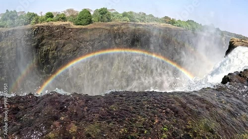 View from the top of Victoria Falls in the Devils Pool, looking over the edge. Victoria Falls is a waterfall on the Zambezi River, located on the border between Zambia and Zimbabwe.