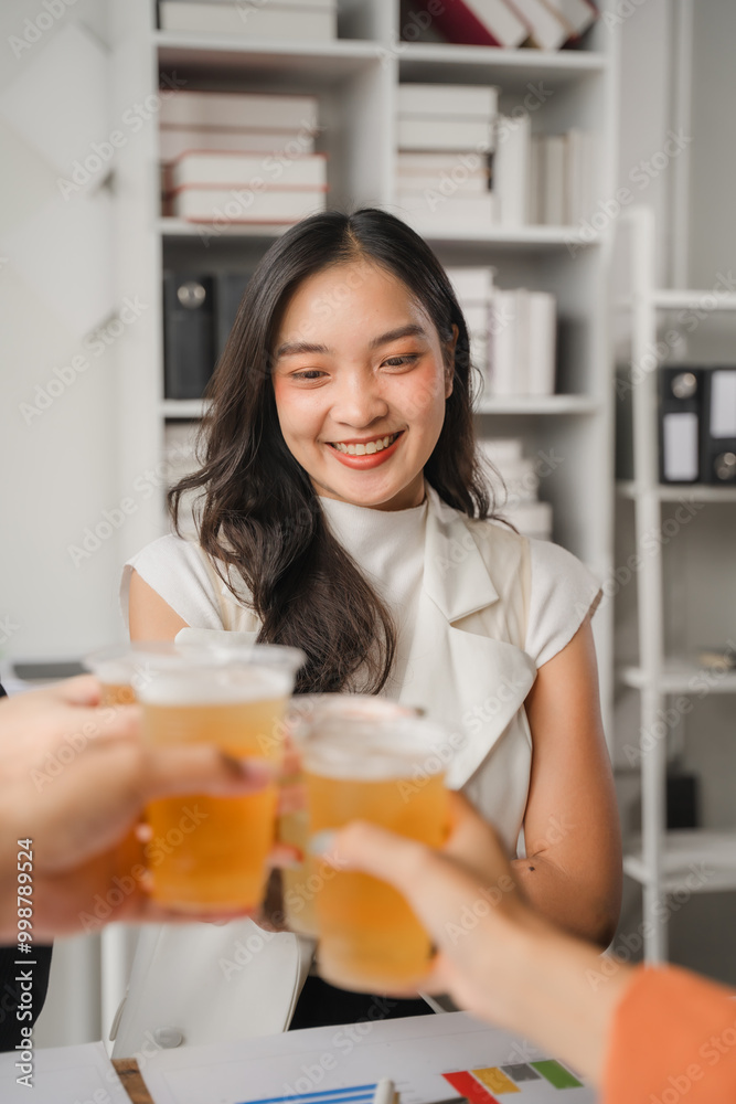 Office Cheers: A young businesswoman raises her glass in a celebratory toast with colleagues, capturing the spirit of camaraderie and success in the workplace. Office Cheers: A young businesswoman raises her glass in a celebratory toast with colleagues, capturing the spirit of camaraderie and success in the workplace.