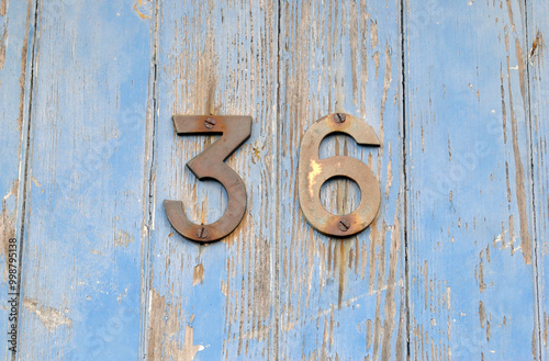 Close Up of Tarnished Metal Number 36 on Blue Painted Door 