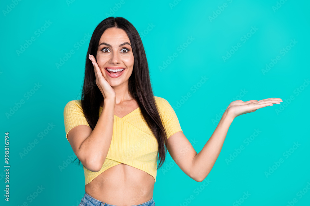 Fototapeta premium Portrait of pretty young woman hold empty space ad wear top isolated on turquoise color background