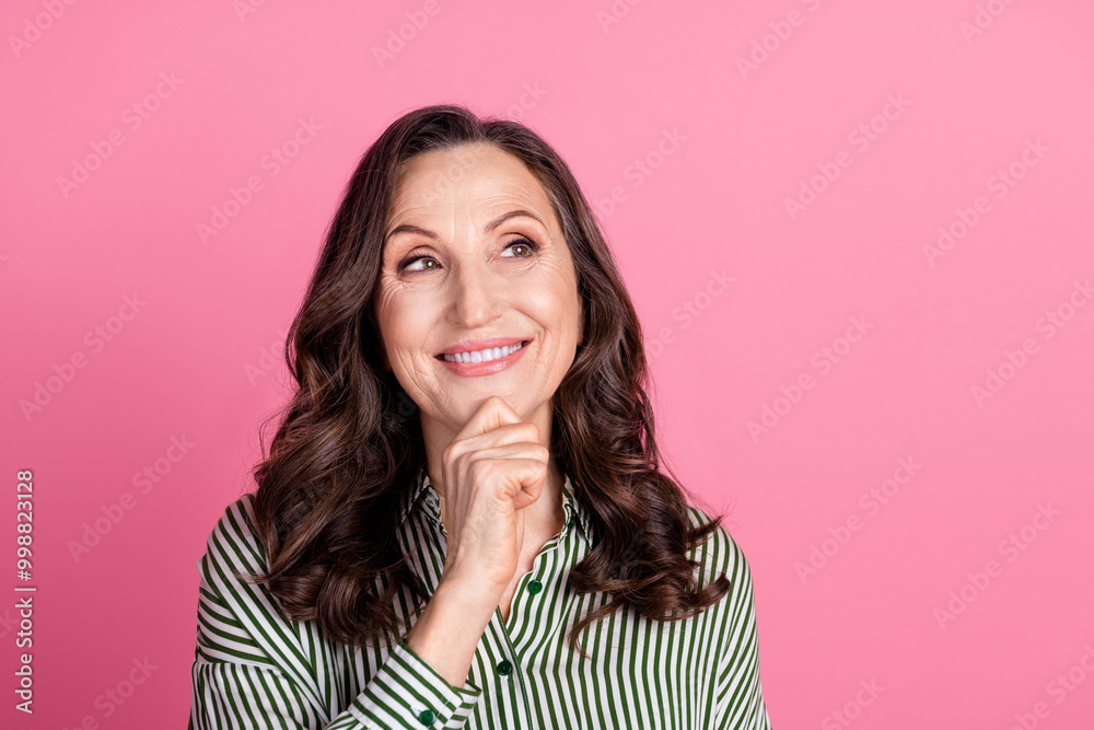 Portrait of pretty aged woman look empty space wear striped shirt isolated on pink color background Portrait of pretty aged woman look empty space wear striped shirt isolated on pink color background