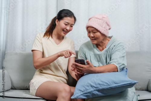 Obraz na plátně A bonding moment captured indoors as an elderly mother and daughter interact with technology