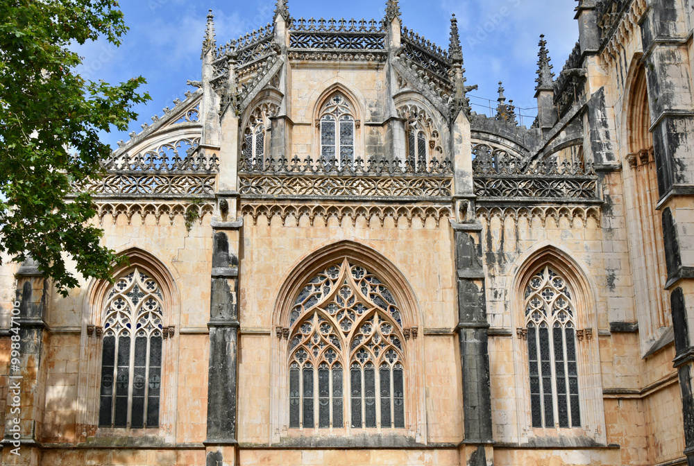 Fototapeta premium Cathedral Windows with Quatrefoil Motif beneath Fleur de Lis Entablature, Batalha Monastery, Portugal