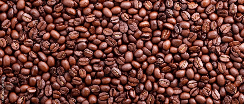 A tall stack of coffee beans, with one pile balanced atop the other A tall stack of coffee beans, with one pile balanced atop the other