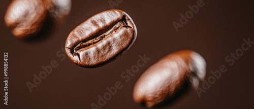  A tight shot of a solitary coffee bean against a warm browning backdrop Three coffee beans lie nearby in the foreground, while an identical trio resides farther back photo