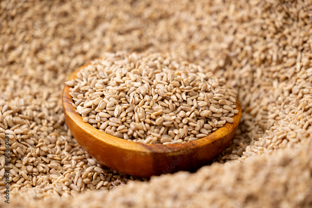 Fresh clean sunflower kernel seeds in wooden plate, oil manufacturing process