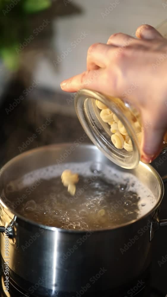 Pasta from the jar is poured into boiling water for cooking. Recipe step by step. Vertical video. Pasta from the jar is poured into boiling water for cooking. Recipe step by step. Vertical video.