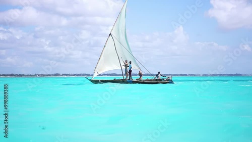 Traditional fishing boat called dhow, sail by Nungwi beach in Zanzibar, African tropical island vacation, tourism destination in Tanzania. 