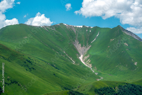 A beautiful view of the Caucasus Mountains in summer in the Gudauri region. The snow melts and a mountain river is born.