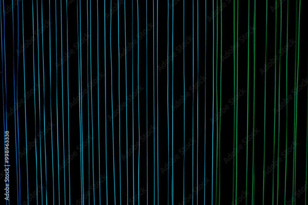 Luminous threads in rainbow colors on a black background, a pattern with multicolored lines Luminous threads in rainbow colors on a black background, a pattern with multicolored lines