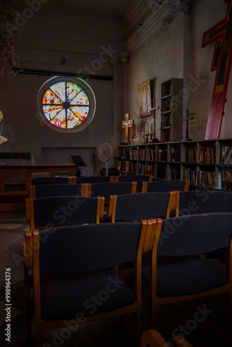 A hall with chairs and a stained glass window in the Lutheran Church Annenkirche. Saint Petersburg, Russia - 27 July 2024 photo