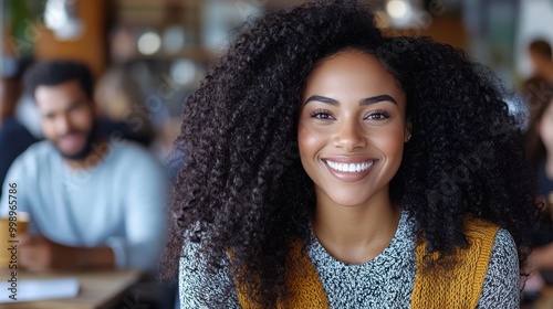 A woman wearing a stylish yellow vest over a sweater seated in a cafe setting, surrounded by patrons and a background featuring bookshelves and a warm ambiance.