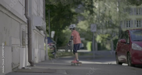 Wallpaper Mural Boy skateboarding on the sidewalk, pushing off to gain speed. The scene highlights a mix of residential buildings and greenery, emphasizing the outdoor, playful atmosphere Torontodigital.ca