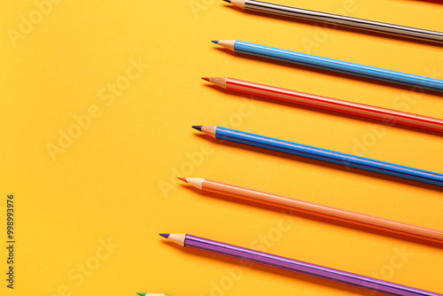 Group of colorful pencils on yellow background photo