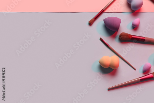 Makeup sponges and brushes on colorful background