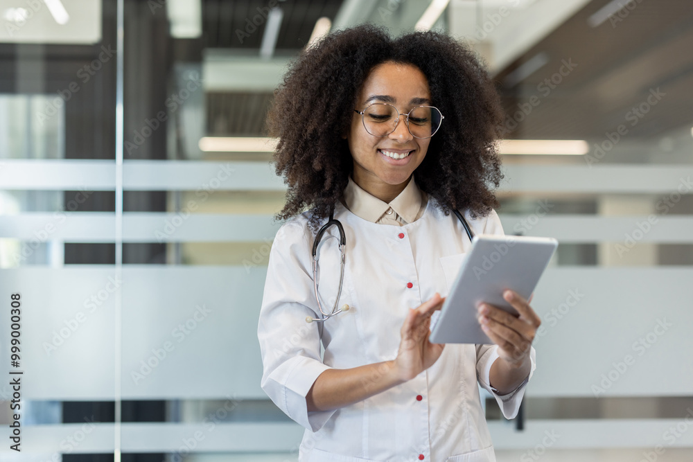 Smiling doctor in white coat using tablet in modern office environment for professional communication Smiling doctor in white coat using tablet in modern office environment for professional communication