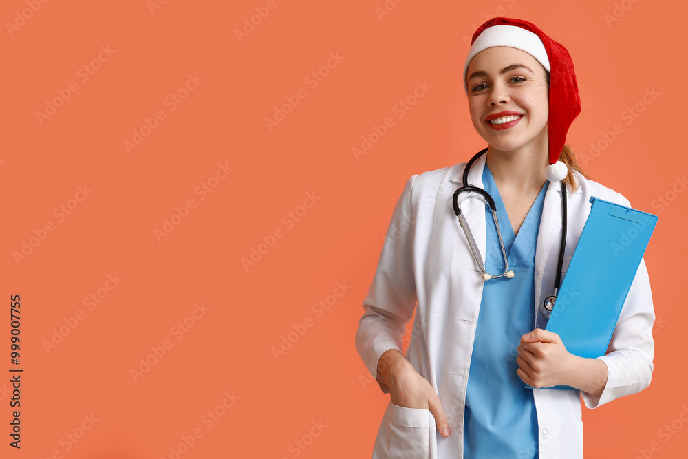 Young female doctor in Santa hat on red background Young female doctor in Santa hat on red background