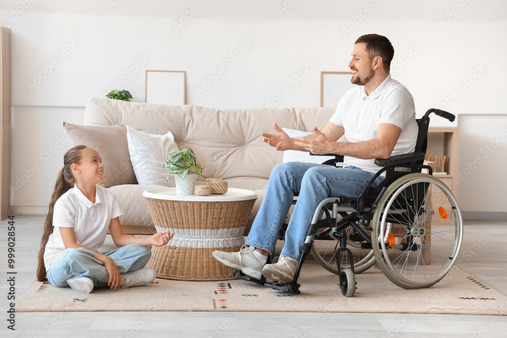 Little girl talking to her father in wheelchair at home Little girl talking to her father in wheelchair at home